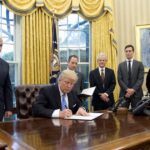 President Donald Trump signs the first of three Executive Orders in the Oval Office of the White House in Washington, D.C on Monday, Jan. 23, 2017. (Ron Sachs - Pool/Getty Images)